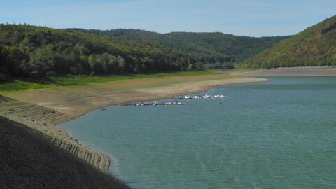 Das Bild zeigt den Edersee mit niedrigem Wasserstand. Das trockene Ufer am rand ist zu erkennen.