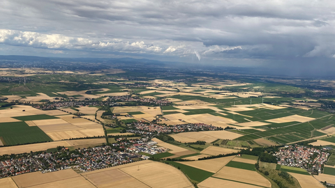 Das Bild teigt ien Landschaft von oben. Zu erkennen sind Felder, Ortschaften und Straßen.