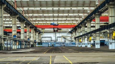 Das Bild zeigt eine leere Werkshalle.