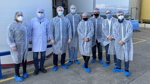 Besuchergruppe mit Kitteln und Masken