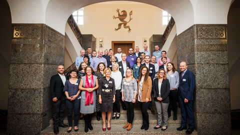 Personengruppe in Gebäude unter Rundbogen