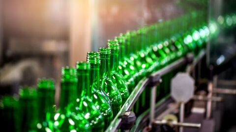 Grüne Glasflaschen auf Fließband