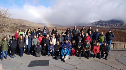 Personengruppe vor Himmel mit Wolken und steiniger Landschaft