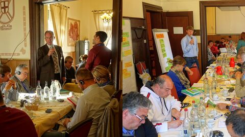 Personen in einem Raum um Tische herum sitzend