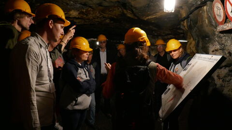 Personen mit gelben Schutzhelmen in einer Höhle