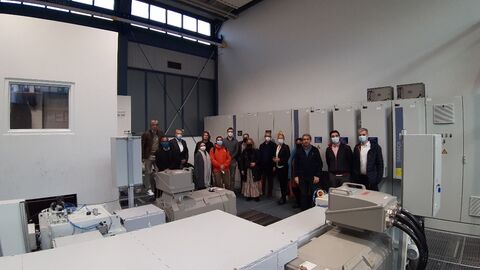 Im Vordergrund große Maschinen im Hintergrund Personengruppe