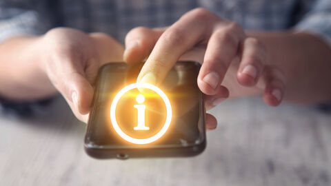 Leuchtender Kreis mit "I" aus Smartphone. Das Smartphone wird von einer Hand gehalten, eine andere zeigt auf das "I"