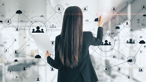 Innovative und intelligentere politische Instrumente Frau in Anzug mit Rücken zum Betrachter vor Scheibe mit abgebildetem Netzwerk