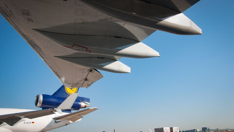 Das Bild zeigt die Tragflächen von einem Airbus von unten. Im Hintergrund ist ein weiterer Airbus zu sehen.